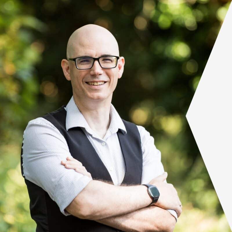 David Ross, smiling, arms folded, outdoors